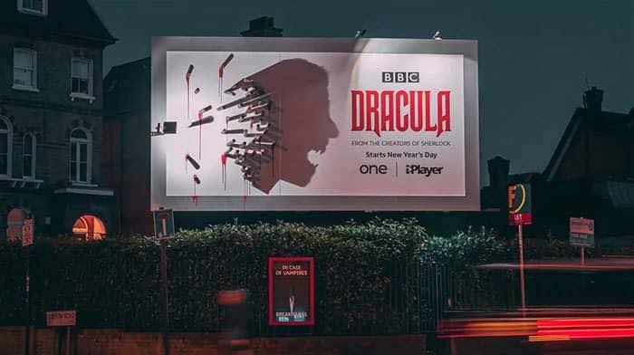 An Out of Home advertisement for the BBC show Dracula. At night, the  shadow cast from the stakes depicts Dracula's head clearly.